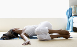 Woman doing back flexibility exercise on a mat on the floor