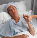 Fotografía de una mujer angustiada, en una cama de hospital