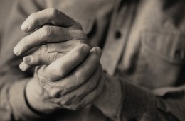Hombre mayor frotando las manos juntas