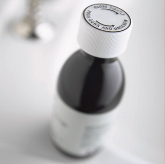 Close up image of a bottle of cough medicine.
